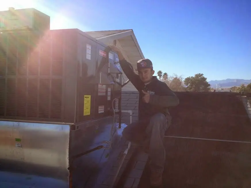 HVAC technician performing AC Tune-Up on a rooftop unit in Sebastian